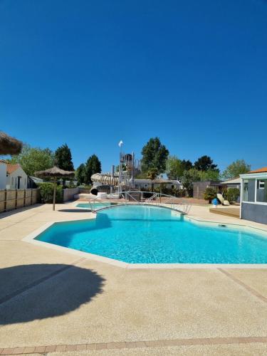 - une grande piscine avec une aire de jeux dans la cour dans l'établissement Mobil Home XXL 4 chambres - Camping La Bolée d'Air, à Saint-Vincent-sur-Jard