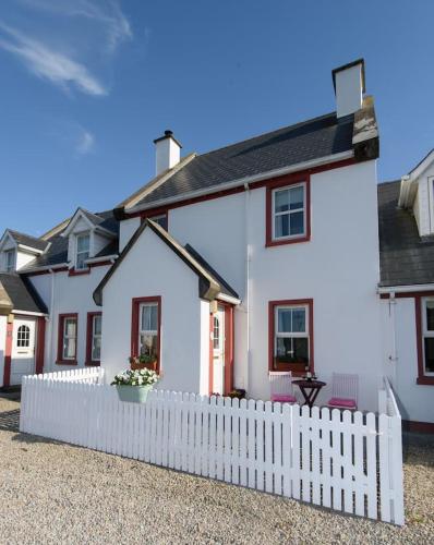 a white house with a white picket fence at Stable View, Clara Meadows Dunfanghy in Dunfanaghy
