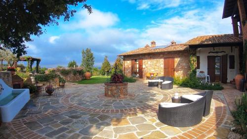 a courtyard with a stone house with a patio at CASALE BELLA VITA 8&4, Emma Villas in Città della Pieve