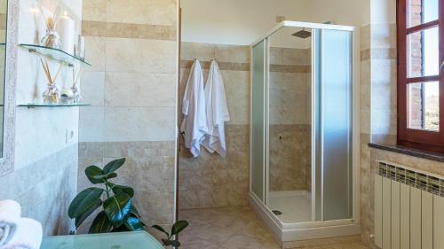a shower with a glass door in a bathroom at CASALE BELLA VITA 8&4, Emma Villas in Città della Pieve