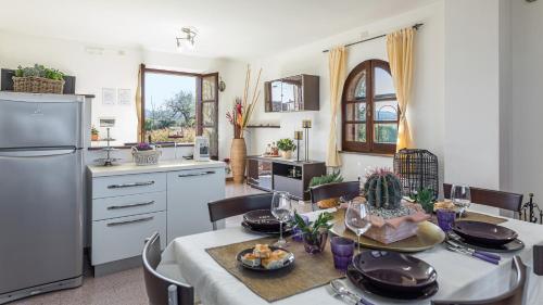 a kitchen and dining room with a table and a refrigerator at CASALE BELLA VITA 8&4, Emma Villas in Città della Pieve