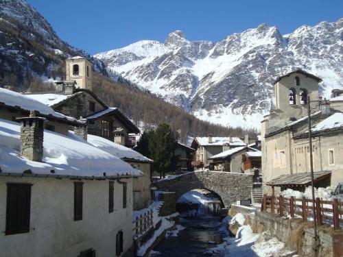 a small town with snow covered mountains in the background at Bed & Breakfast Barba Bertu in Frassino