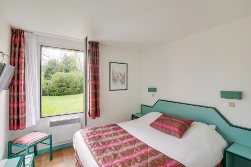 1 dormitorio con cama y ventana en Le Relais de Voisins, en Voisins-le-Bretonneux