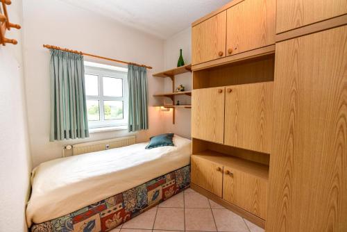 a small bedroom with a bed and a window at "Appartementhaus Deichgraf" Appartement D341 in Döse