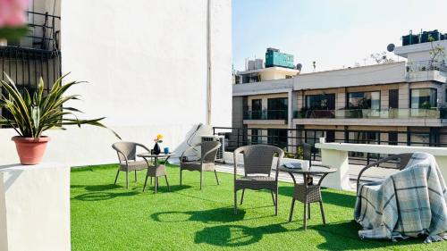 un patio con sillas y mesas en la azotea en BluO Studio - Defence Colony - BathTub, Balcony en Nueva Delhi