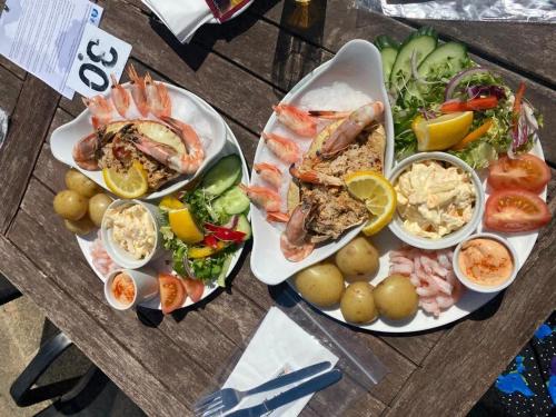 a table topped with plates of seafood and vegetables at Dog and Duck Leisure Park in Kent