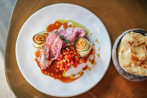 a plate of food with meat and vegetables on a table at Hotel Sanglier in Durbuy