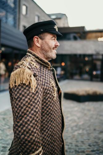 a man is wearing a hat and a jacket at Hotel Sanglier in Durbuy