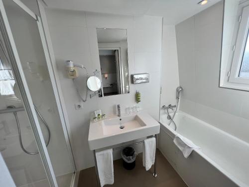 a white bathroom with a sink and a shower at Holiday Inn Paris-Auteuil by IHG in Paris