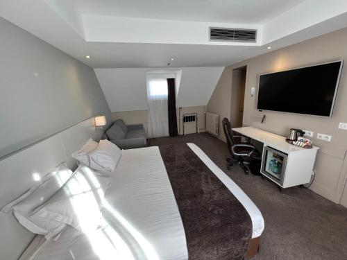 a hotel room with a bed and a desk and a tv at Holiday Inn Paris-Auteuil, an IHG Hotel in Paris