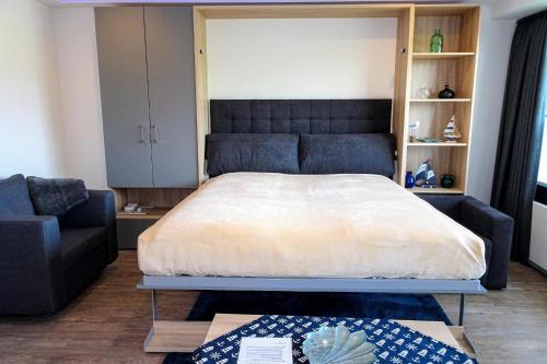 ein Schlafzimmer mit großem Bett und Couch in der Unterkunft Haus "Jan am Strand" Appartement JAN002 in Döse