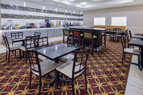 a dining room with tables and chairs and a kitchen at La Quinta by Wyndham Garland Harbor Point in Garland