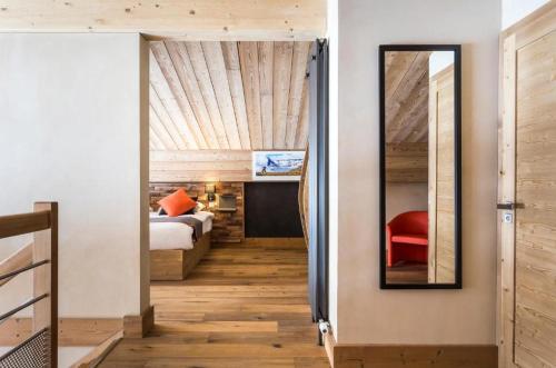 a bedroom with a bed and a mirror on the wall at Hôtel Saint Charles Val Cenis in Lanslebourg-Mont-Cenis