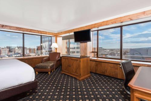 una habitación de hotel con una cama y un televisor en The Antlers, a Wyndham Hotel, en Colorado Springs