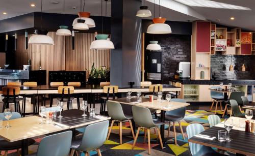 a restaurant with tables and chairs and lights at Atura Wellington in Wellington