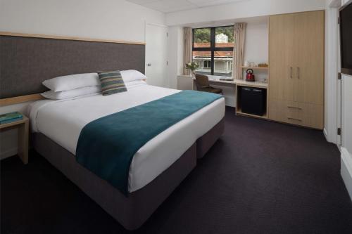 a hotel room with a large bed and a kitchen at Atura Wellington in Wellington