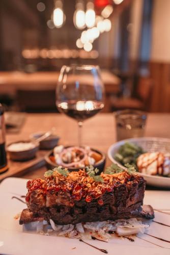 a plate of food and a glass of wine on a table at Hotel Sanglier in Durbuy