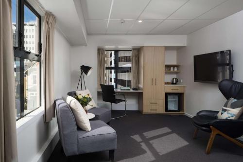a living room with two chairs and a television at Atura Wellington in Wellington