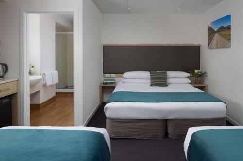 a hotel room with a bed and a bathroom at Atura Wellington in Wellington