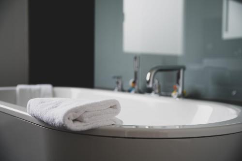 a white towel sitting in a bathroom sink at Landhaus Hohenlohe in Rot am See