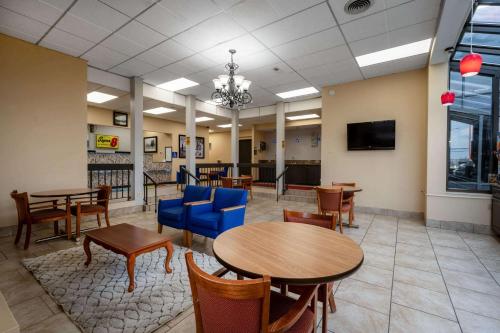a waiting room with tables and chairs and a tv at Days Inn by Wyndham Perrysburg Toledo in Perrysburg
