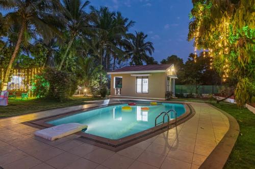 a swimming pool in the backyard of a house at SaffronStays Serene Retreat, Alibaug in Alibaug