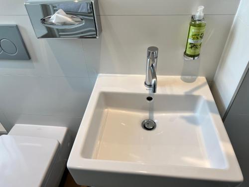 a white sink in a small bathroom at Holiday Inn Paris-Auteuil by IHG in Paris