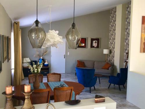 - un salon avec une table et des chaises bleues dans l'établissement Maison du Midi, 2 Gîtes de charme, à Ginestas