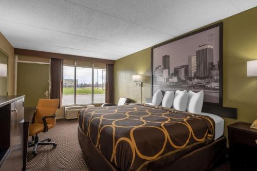 a hotel room with a bed and a large window at Super 8 by Wyndham Perrysburg-Toledo in Perrysburg