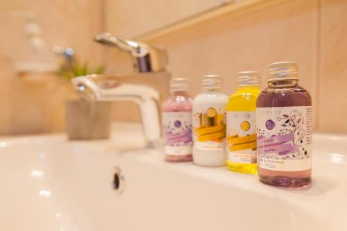 a bathroom sink with several bottles of liquid at Hotel Villa Džamonja in Bol