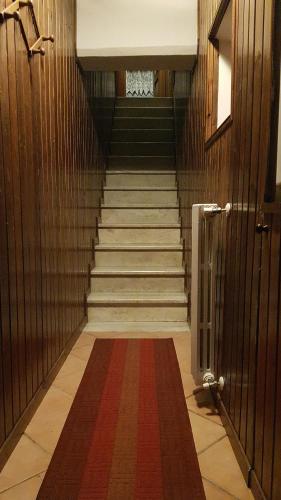 un pasillo con una escalera con alfombra roja en Armida, en Pescasseroli