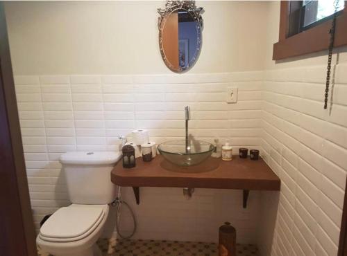 a bathroom with a bowl sink and a toilet at Bangalô na Natureza in Nova Friburgo