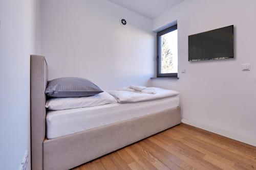 a couch in a room with a flat screen tv at City Suites Murnau in Murnau am Staffelsee