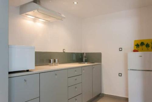 a kitchen with white cabinets and a white refrigerator at Chorio House Platanias in Vrísai