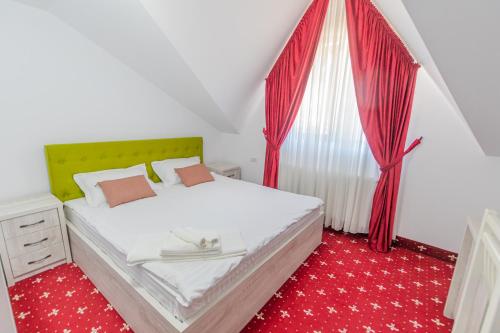a bedroom with a bed and a window with red carpet at SOMARA in Găineşti