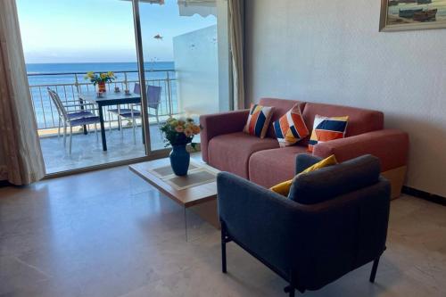 un salon avec un canapé et une table dans l'établissement Seafront one bedroom apartment with a terrasse swimming pool and a parking, à Antibes