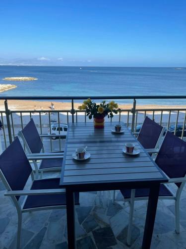 - une table bleue et des chaises avec vue sur la plage dans l'établissement Seafront one bedroom apartment with a terrasse swimming pool and a parking, à Antibes