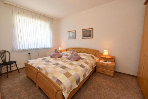 ein Schlafzimmer mit einem Bett mit zwei Kissen darauf in der Unterkunft Haus "Luv und Lee" Appartement LEE02 in Döse