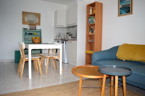 salon z kanapą i stołem w obiekcie Triplex avec jardinet - wifi - à 400m de la plage w mieście Courseulles-sur-Mer