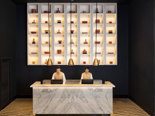 two people sitting at a counter with their laptops at Welcomhotel By ITC Hotels, Guntur in Guntūr