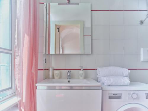 a bathroom with a sink and a washing machine at Medusa Apartment - Piazza 2 in Finale Ligure