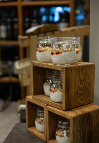 a wooden shelf with four jars of food at DiliJazz Hotel & Restaurant in Dilijan