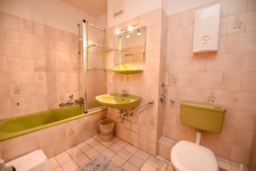 a bathroom with a green toilet and a sink at Haus "Luv und Lee" Appartement LEE06 in Döse
