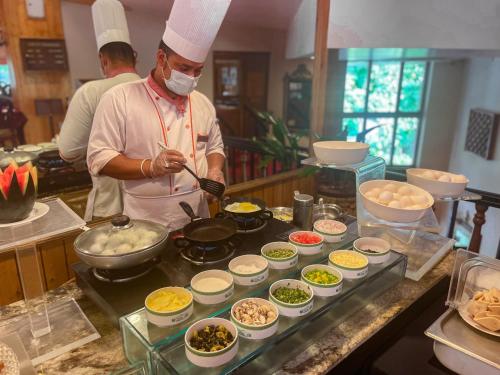 een chef-kok bereidt eten in een keuken bij Span Resort and Spa, Manali in Manāli