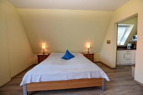 ein Schlafzimmer mit einem Bett mit einem blauen Kissen darauf in der Unterkunft Haus "Luv und Lee" Appartement LEE17 in Döse