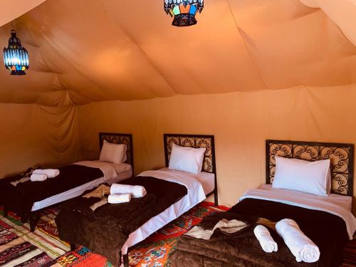 a room with two beds in a tent at Sahara wellness camp in Merzouga