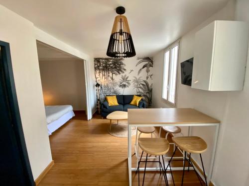 Il comprend une petite cuisine et un salon avec une table et des chaises. dans l'établissement magnifiques appartements au coeur de Bordeaux, à Bordeaux