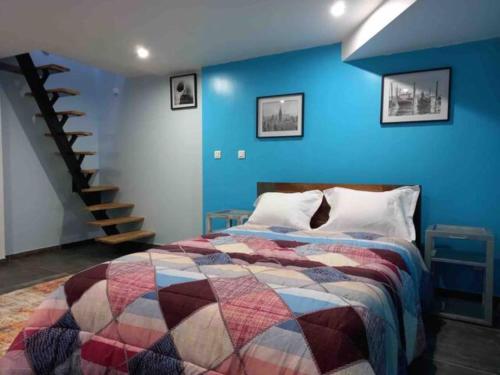 1 dormitorio con cama y pared azul en WIFI - PARKING - SUPERBE T3 SPACIEUX ET MODERNE!!!!, en Saint-Denis