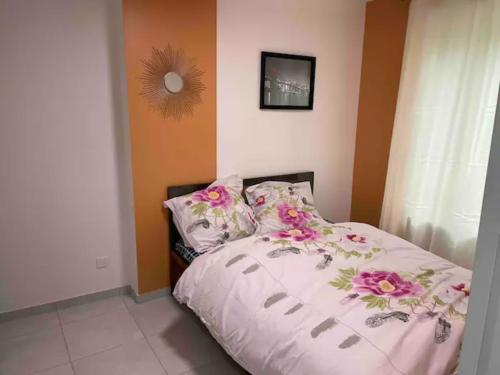 a bedroom with a bed with flowers on it at WIFI - PARKING - SUPERBE T3 SPACIEUX ET MODERNE!!!! in Saint-Denis