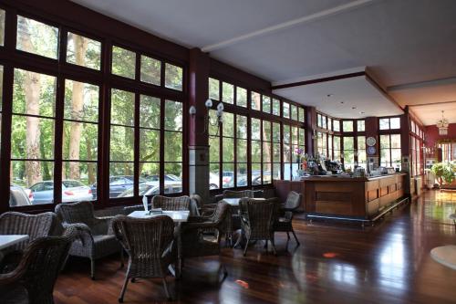 a restaurant with tables and chairs and large windows at Gran Hotel Balneario de Liérganes in Liérganes